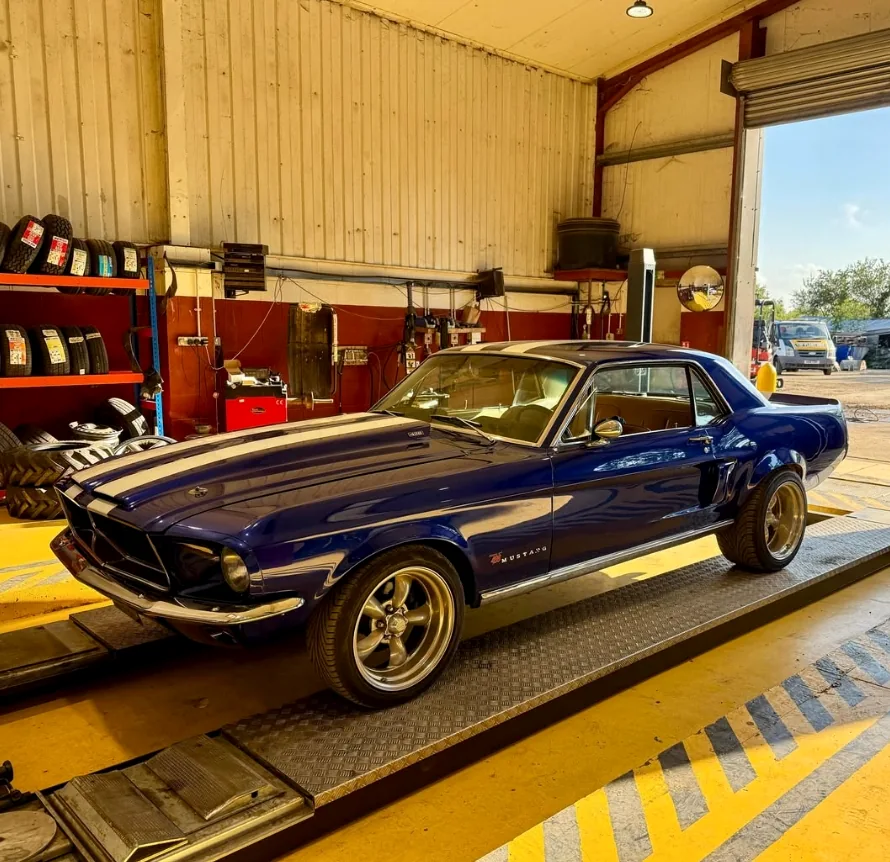 A classic blue Ford Mustang in the Top Plant Garage workshop