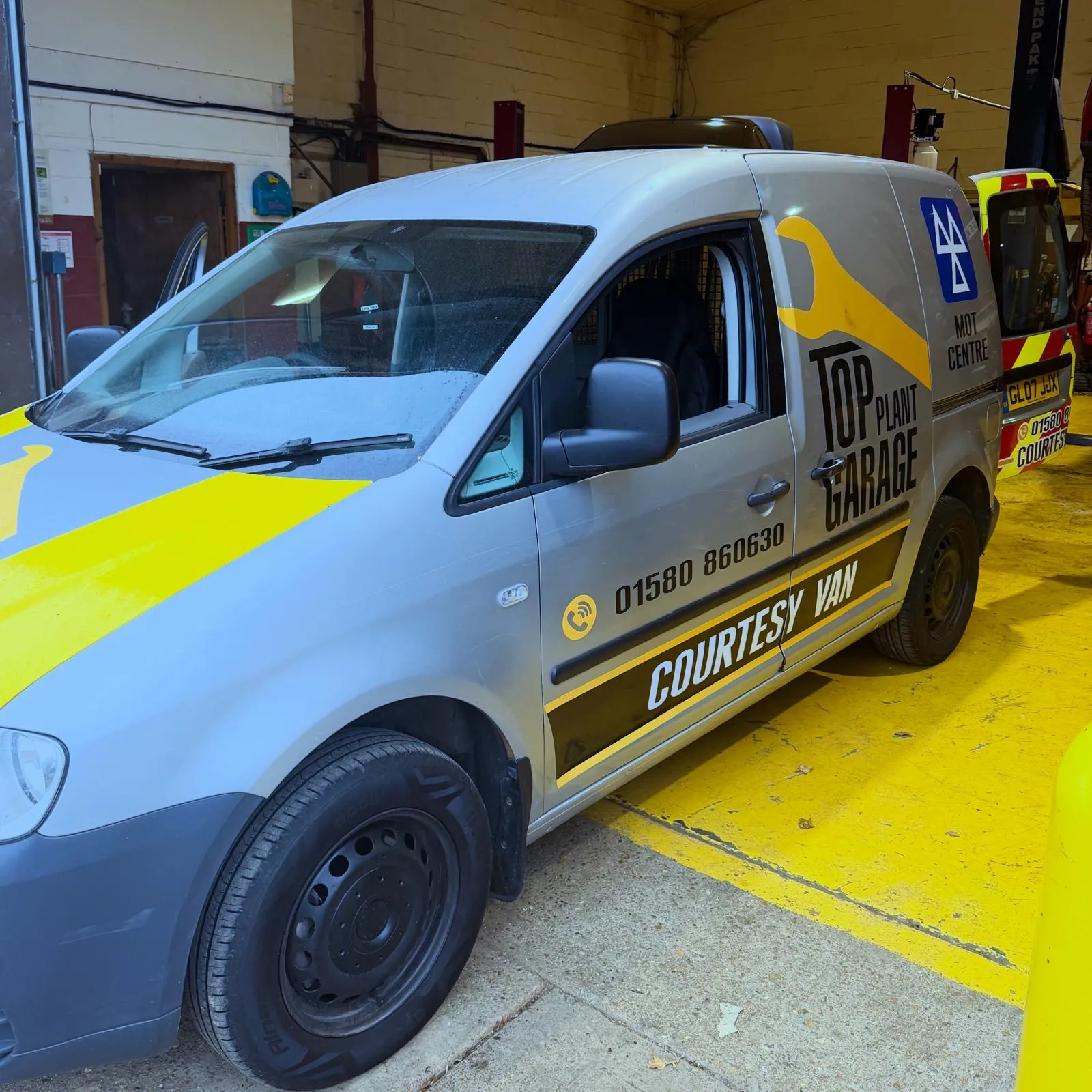 Top Plant Garage branded courtesy van parked inside the workshop