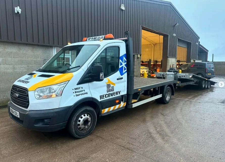 Top Plant Garage branded recovery flatbed parked outside the workshop